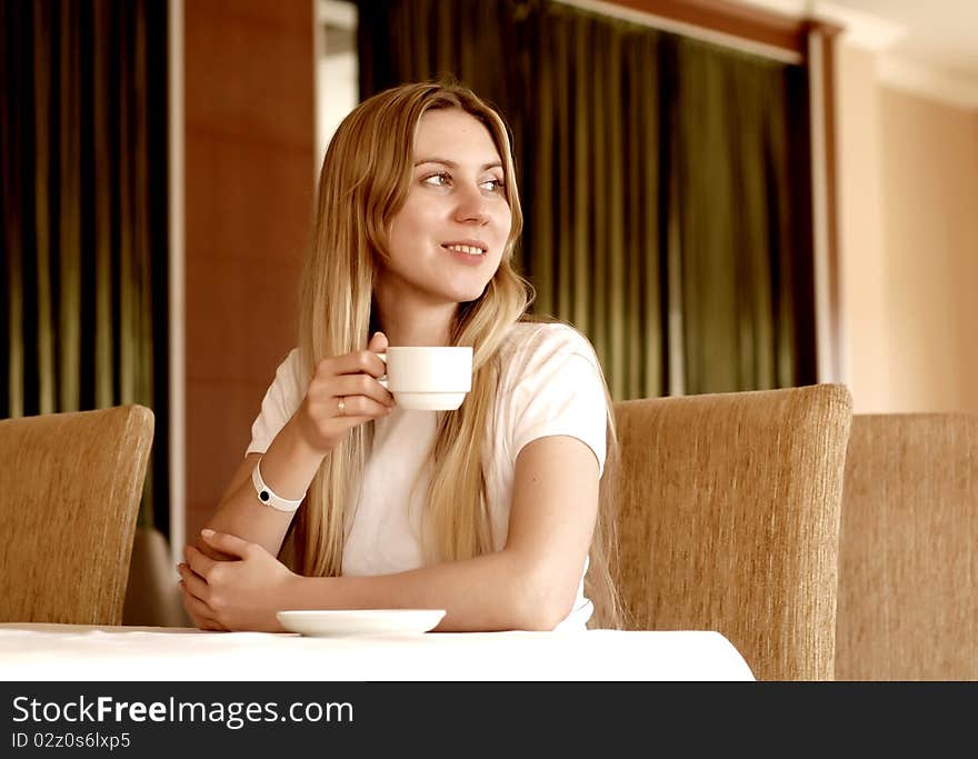 Happy woman in white with cup of coffee or tea. Happy woman in white with cup of coffee or tea.