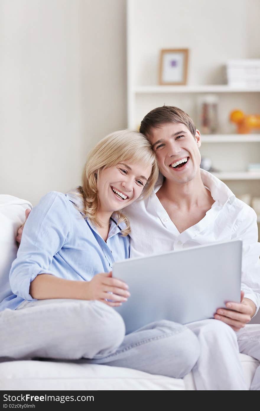 Laughing young couple with laptop at home. Laughing young couple with laptop at home