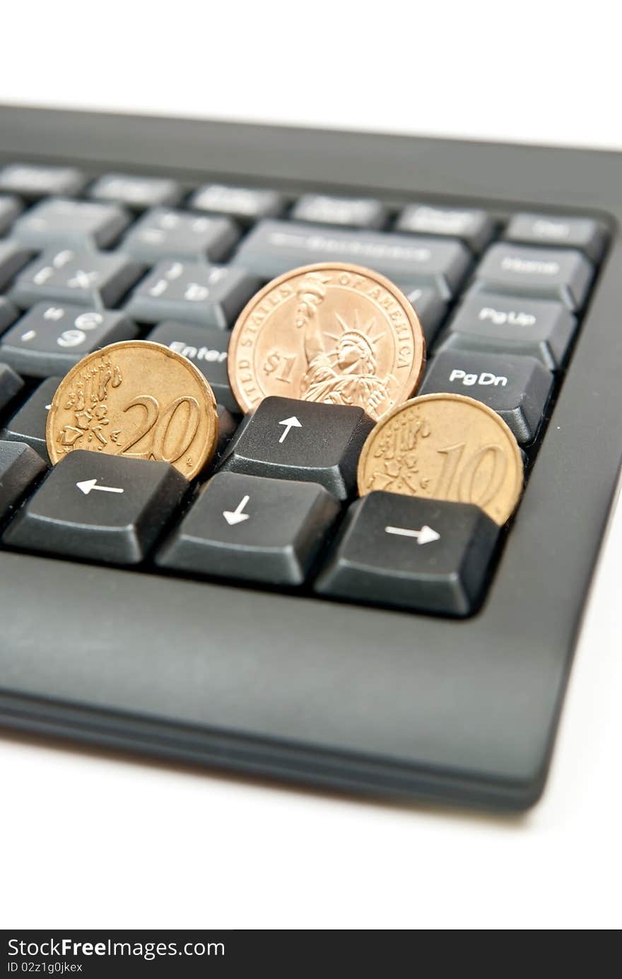 Three coins on a black computer keyboard. Three coins on a black computer keyboard