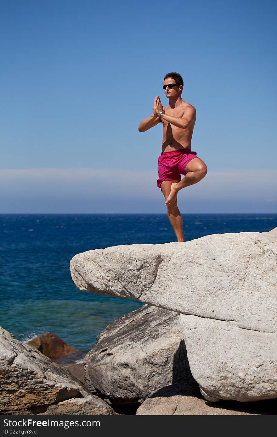 Man Meditating On A Rocky Beach