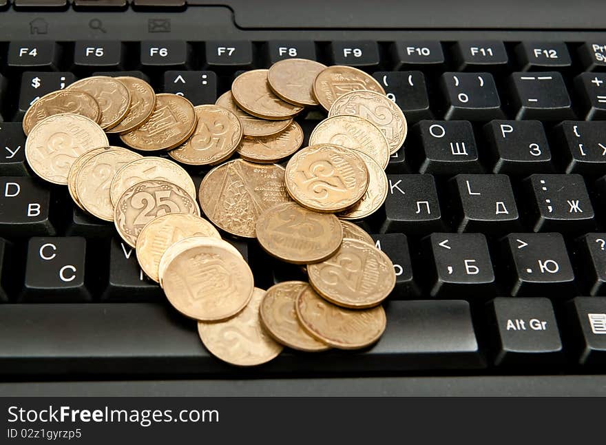 Heap of yellow coins on black keyboard. Heap of yellow coins on black keyboard