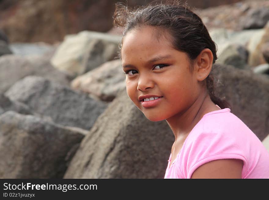 Ethnic school girl on beach with smiling eyes