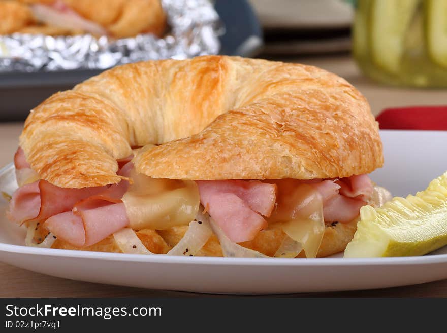 Ham and cheese with onions on a croissant bun. Ham and cheese with onions on a croissant bun