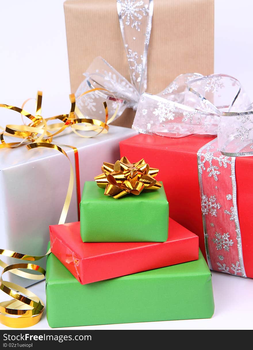 Gifts in silver, green, brown and red wrapping with bows in close up