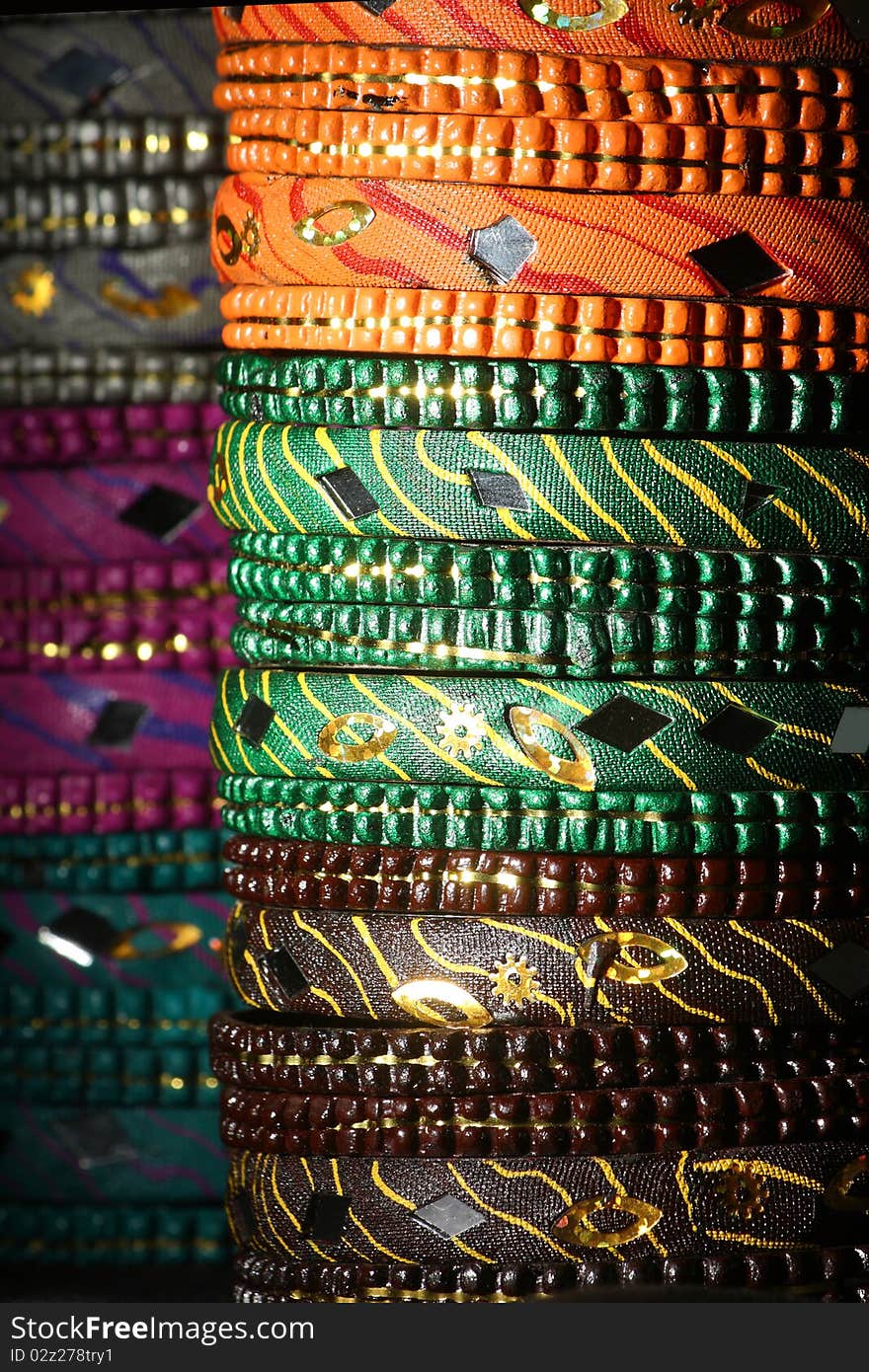 Background created from stacks of colorful Asian bangles with a dark tone. Background created from stacks of colorful Asian bangles with a dark tone.