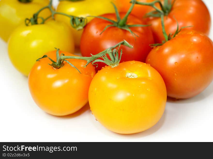 Many colorful fresh tomatoes on white background