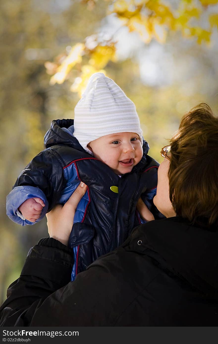 Mother holding her baby son in the autumn park. Mother holding her baby son in the autumn park