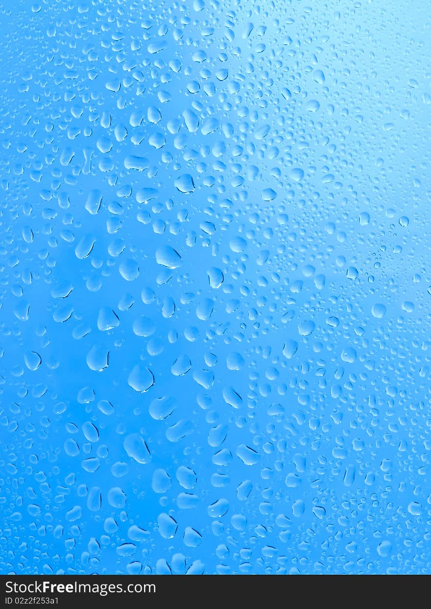 Blue water drops on glass