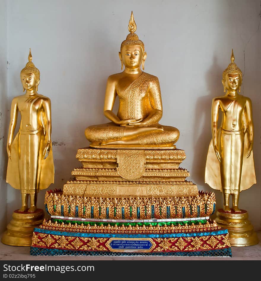 Three thai golden buddha image at white wall in temple