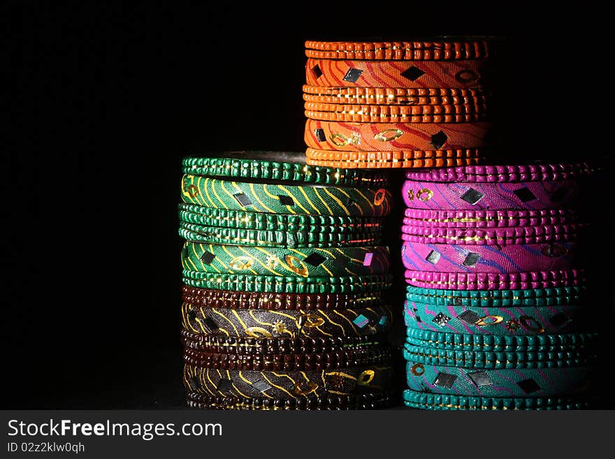 Background created from stacks of colorful Asian bangles with a dark tone. Background created from stacks of colorful Asian bangles with a dark tone.