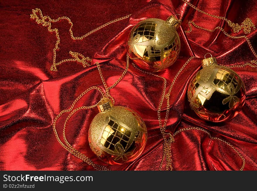 Shiny gold baubles with red background material. Shiny gold baubles with red background material