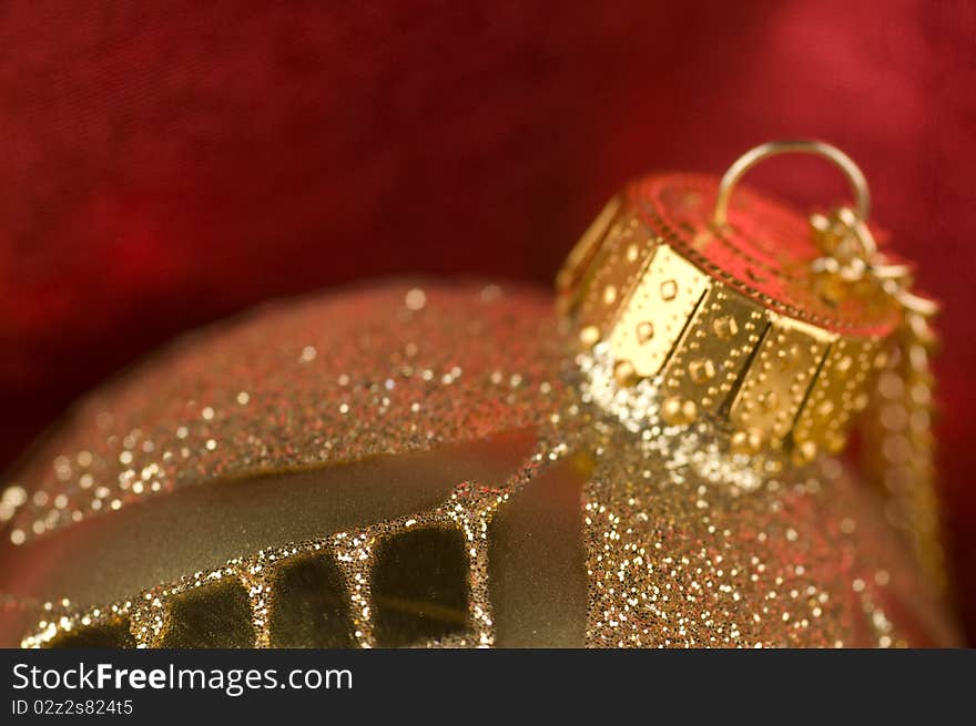 Gold bauble with red backdrop