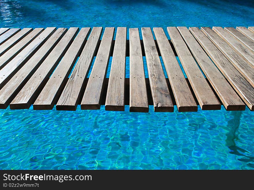 The wooden bridge in a swimming pool. The wooden bridge in a swimming pool