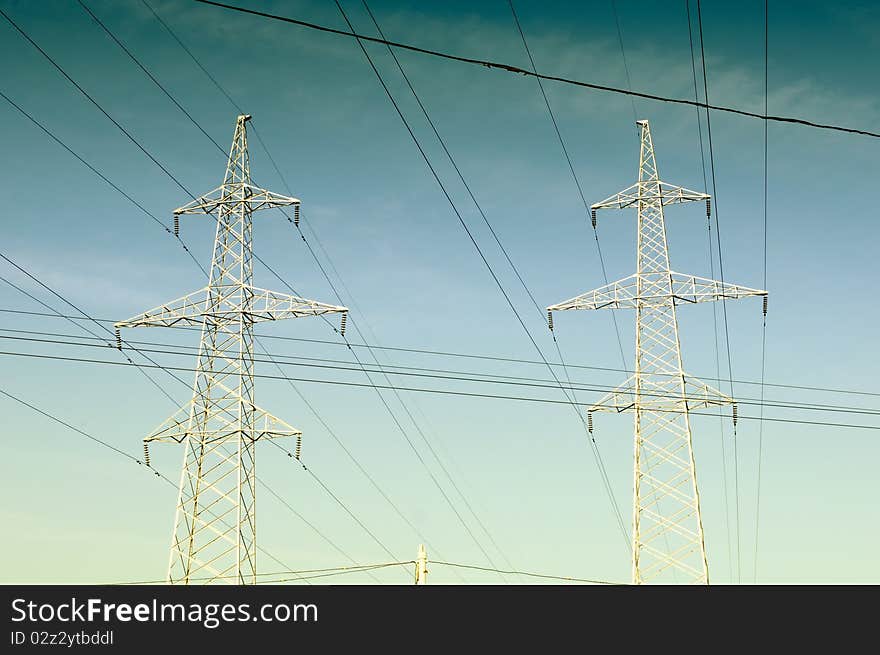 Electricity pylons and power lines on a blue sky background