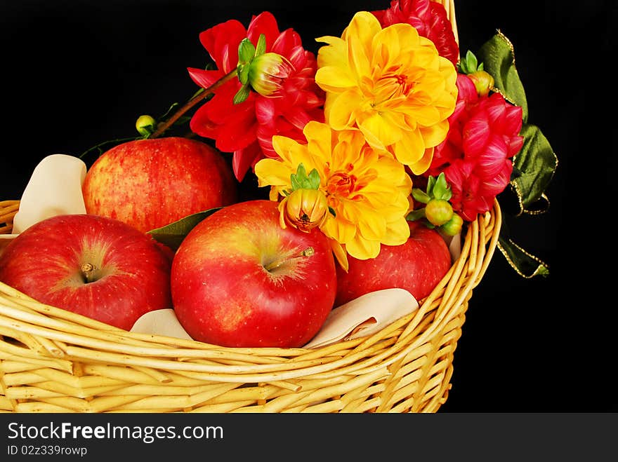 Autumn Basket with red apples and flowers isolated on the black background. Autumn Basket with red apples and flowers isolated on the black background.