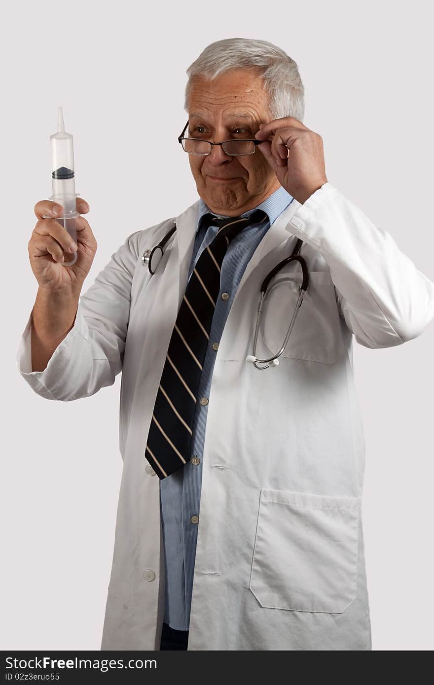 Elderly man doctor with grey hair and eyeglasses wearing white lab coat holding a syringe. Elderly man doctor with grey hair and eyeglasses wearing white lab coat holding a syringe