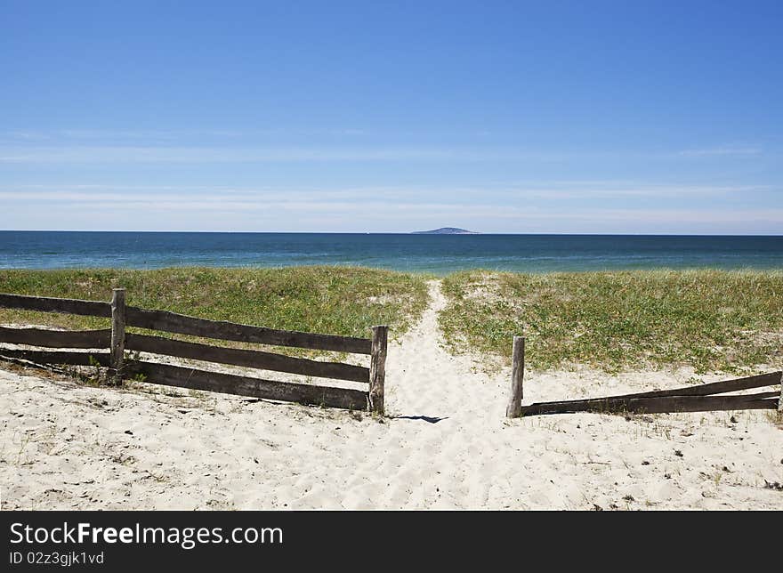 Pathway leading to the ocean. A small island is seen in the far distance.