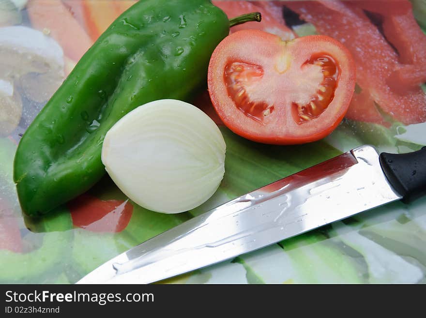 Fresh vegetables on a cut table. Tomato, onion and pepper