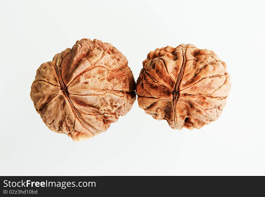 Two organic walnuts isolated on white background.