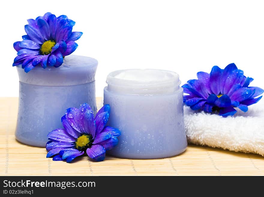 Spa essentials, cream and towel with blue flowers