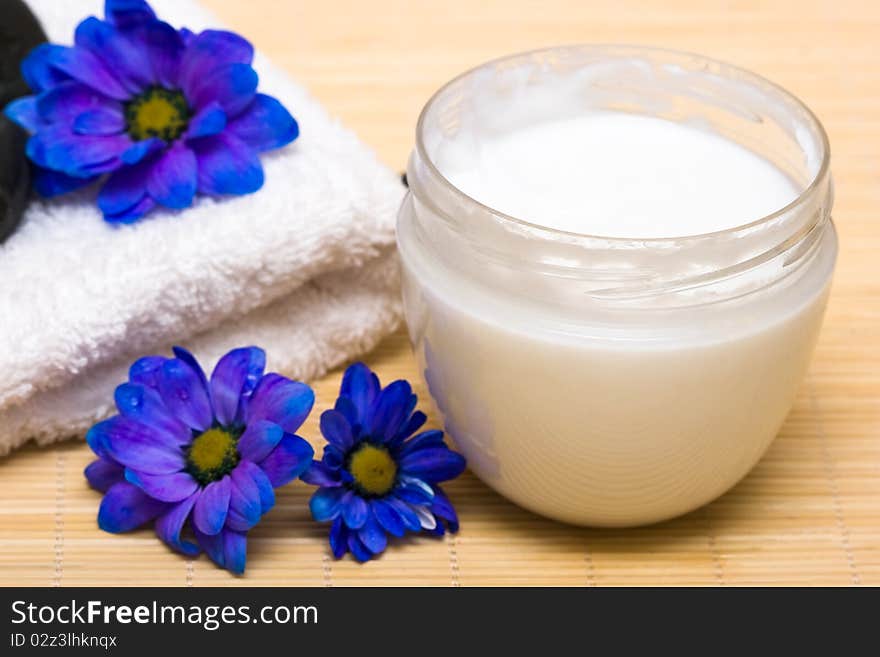 Spa essentials, cream and towel with blue flowers