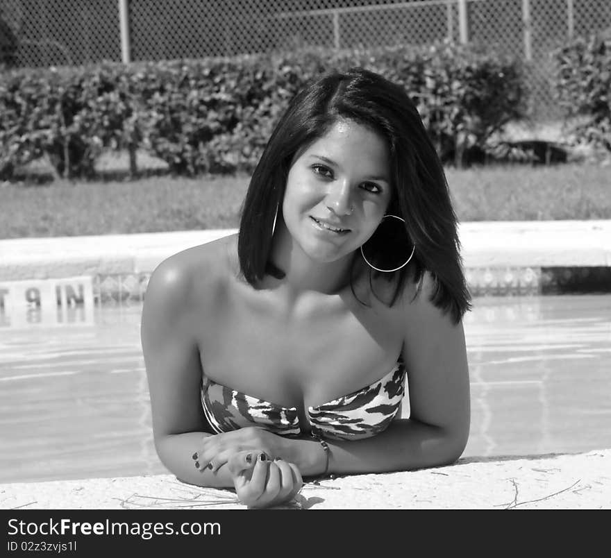 Young girl in the pool and smiling, big hoop earings. Young girl in the pool and smiling, big hoop earings