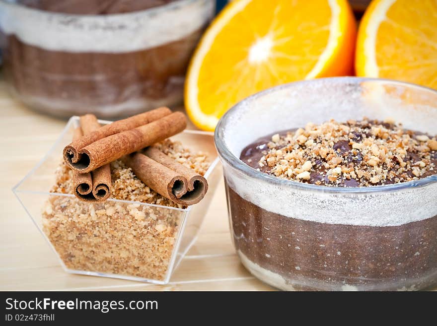 Chocolate cake surrounded by the ingredients, including chocolate, cinnamon, and a sliced orange. Chocolate cake surrounded by the ingredients, including chocolate, cinnamon, and a sliced orange.