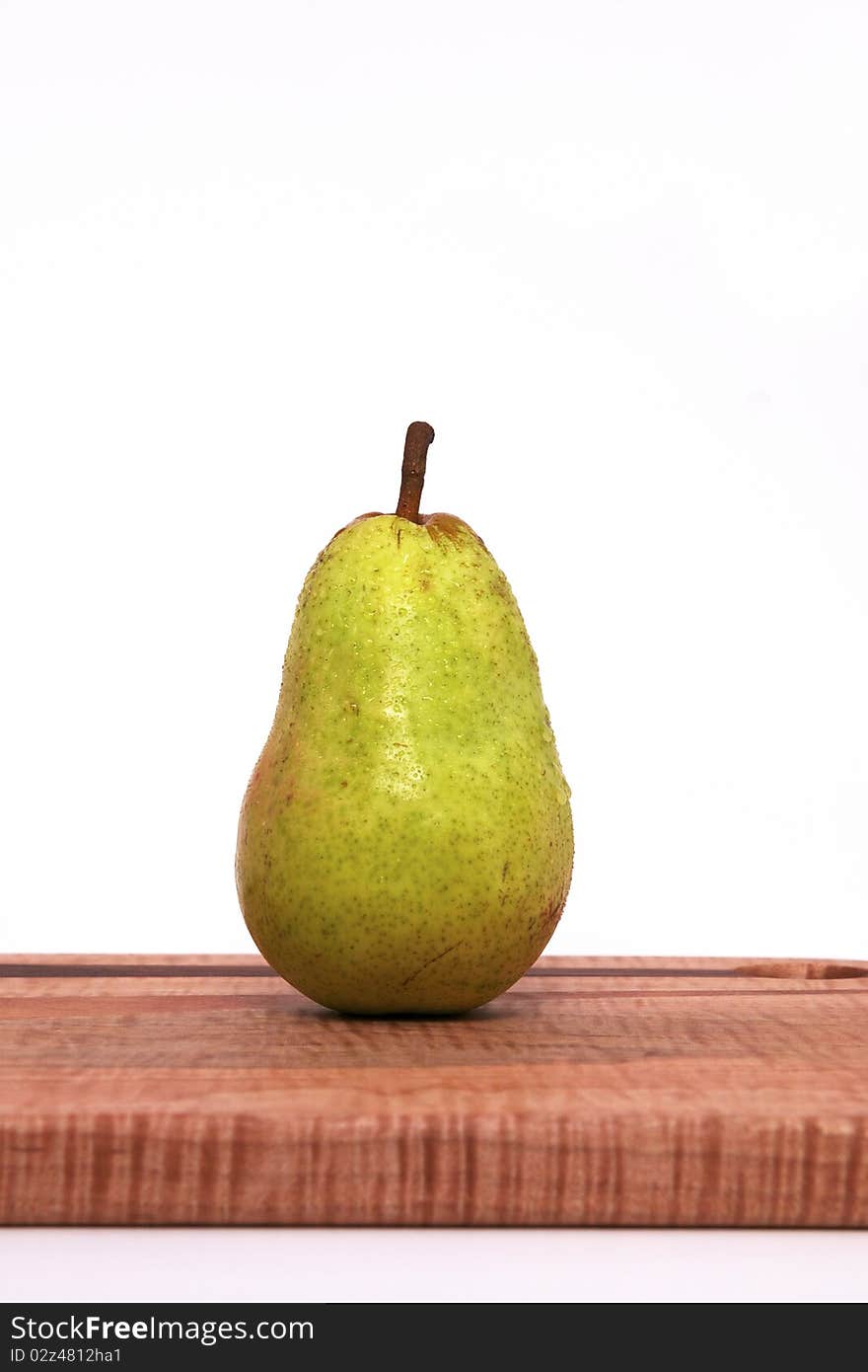 A Single Pear on a Cutting Board Isolated against a White Background