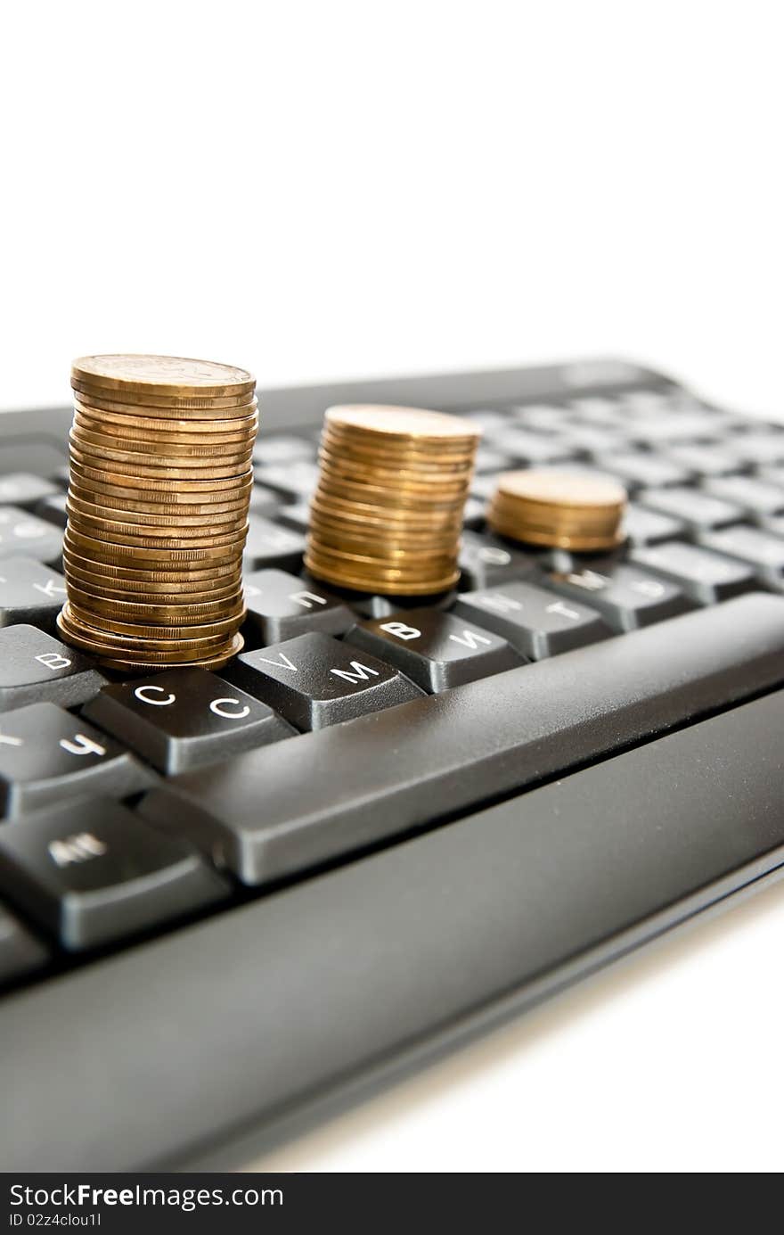 Stacks of coins on a black computer keyboard. Stacks of coins on a black computer keyboard