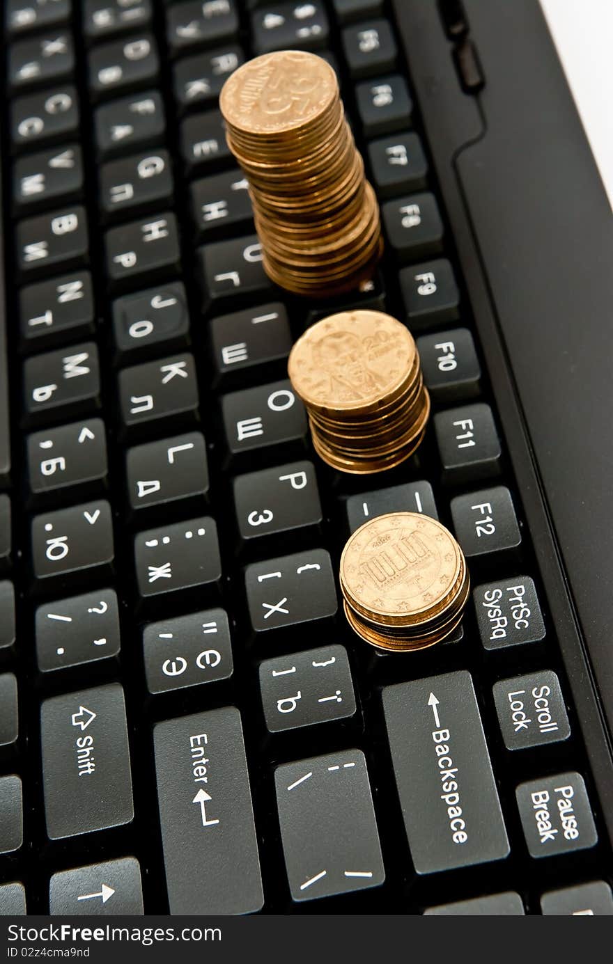 Stacks of coins on a black computer keyboard. Stacks of coins on a black computer keyboard