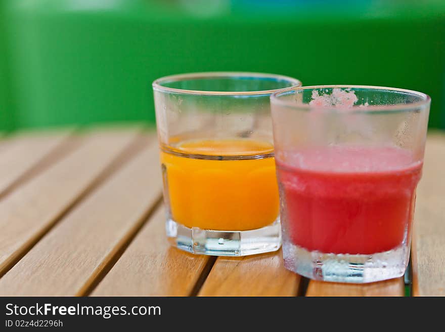 2 glass of fruit-juices on the wooden table. 2 glass of fruit-juices on the wooden table