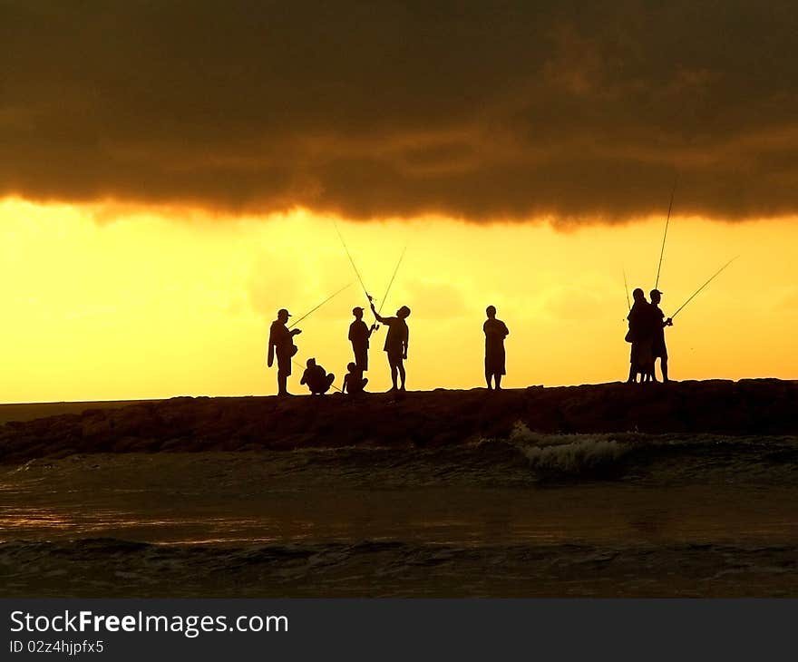 Fishermen outlines against the evening sky, Bali