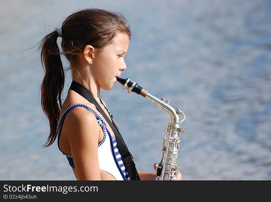 Girl with saxophone outdoor.Near Kiev,Ukraine