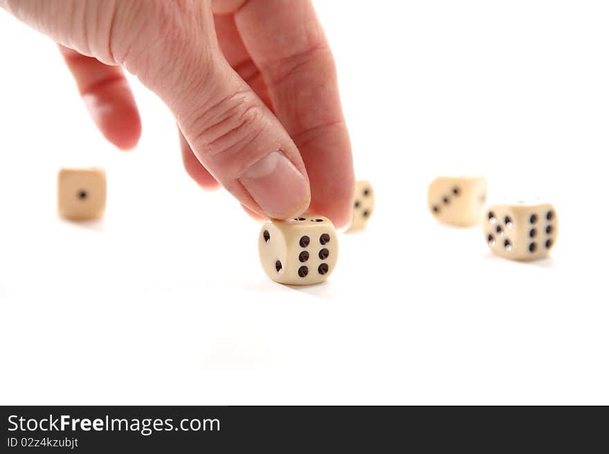 Fingers are pointing to a dice on a white background. Fingers are pointing to a dice on a white background