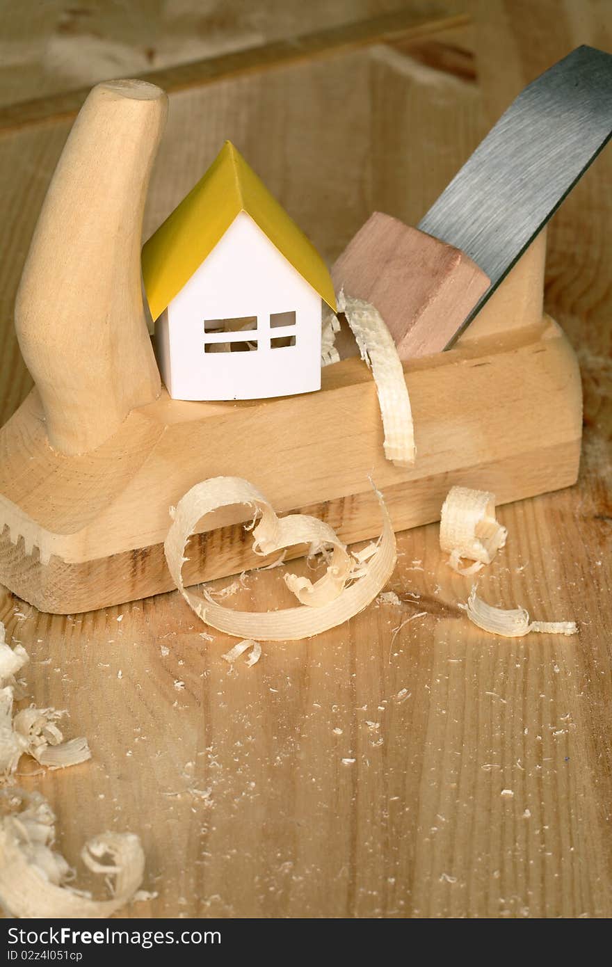 Paper house standing on wood planer on wooden background. Paper house standing on wood planer on wooden background