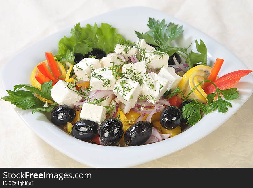 Slices of cheese in a salad of feta cheese and diced vegetables