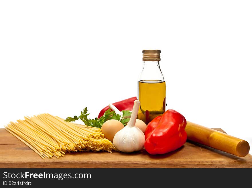 Close-up shot of spaghetti and vegetables on wooden board. Studio shot