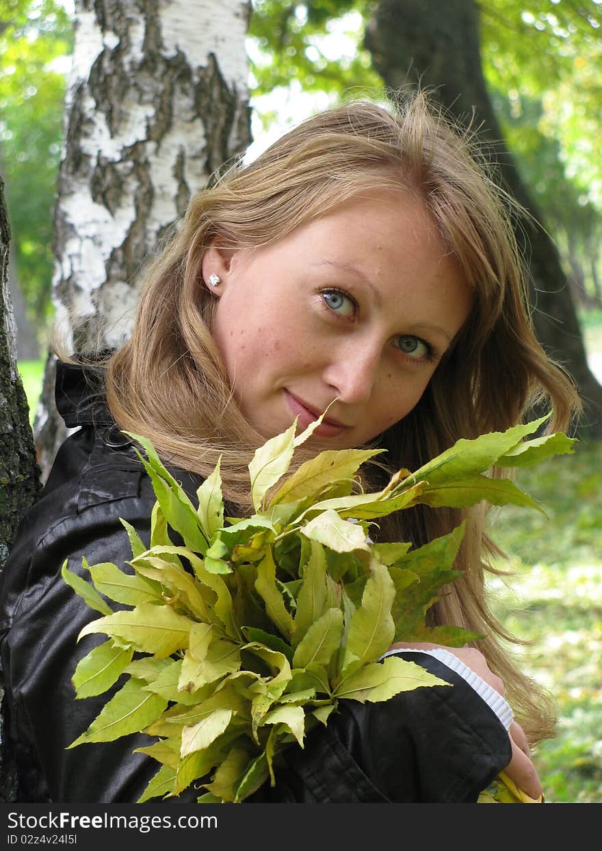 Blonde girl with the yellow leaves in park. Blonde girl with the yellow leaves in park