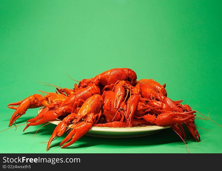 Plate full of red crayfishes, green background. Plate full of red crayfishes, green background