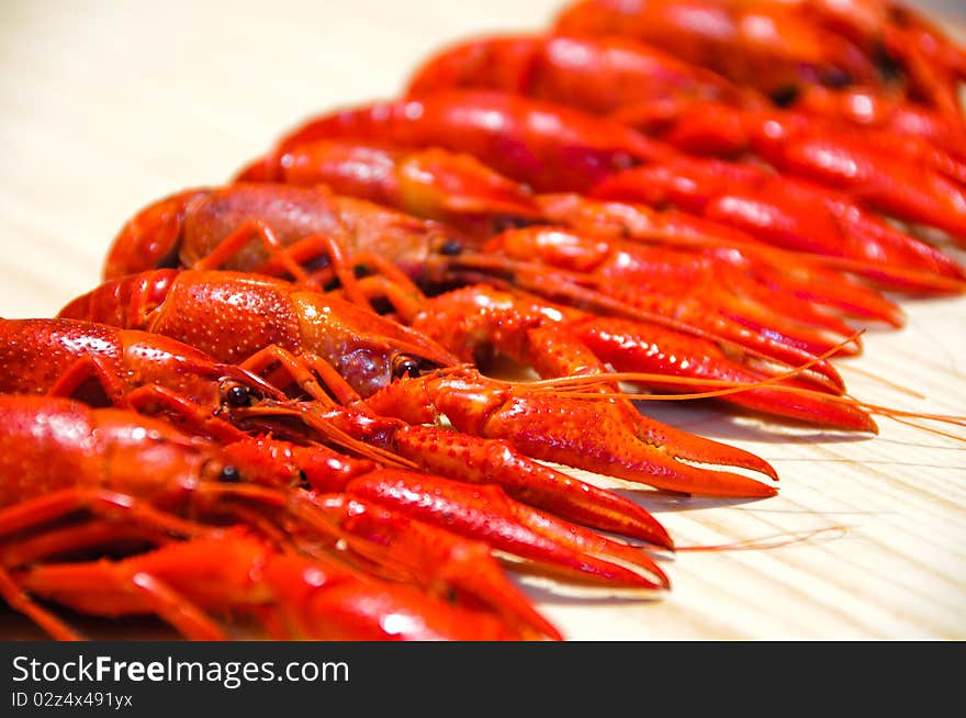 Row of a red crayfishes, wooden background