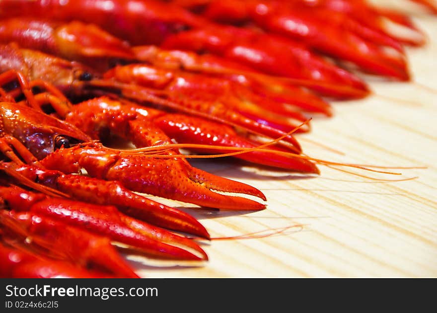 Row of a red crayfishes, wooden background. Row of a red crayfishes, wooden background