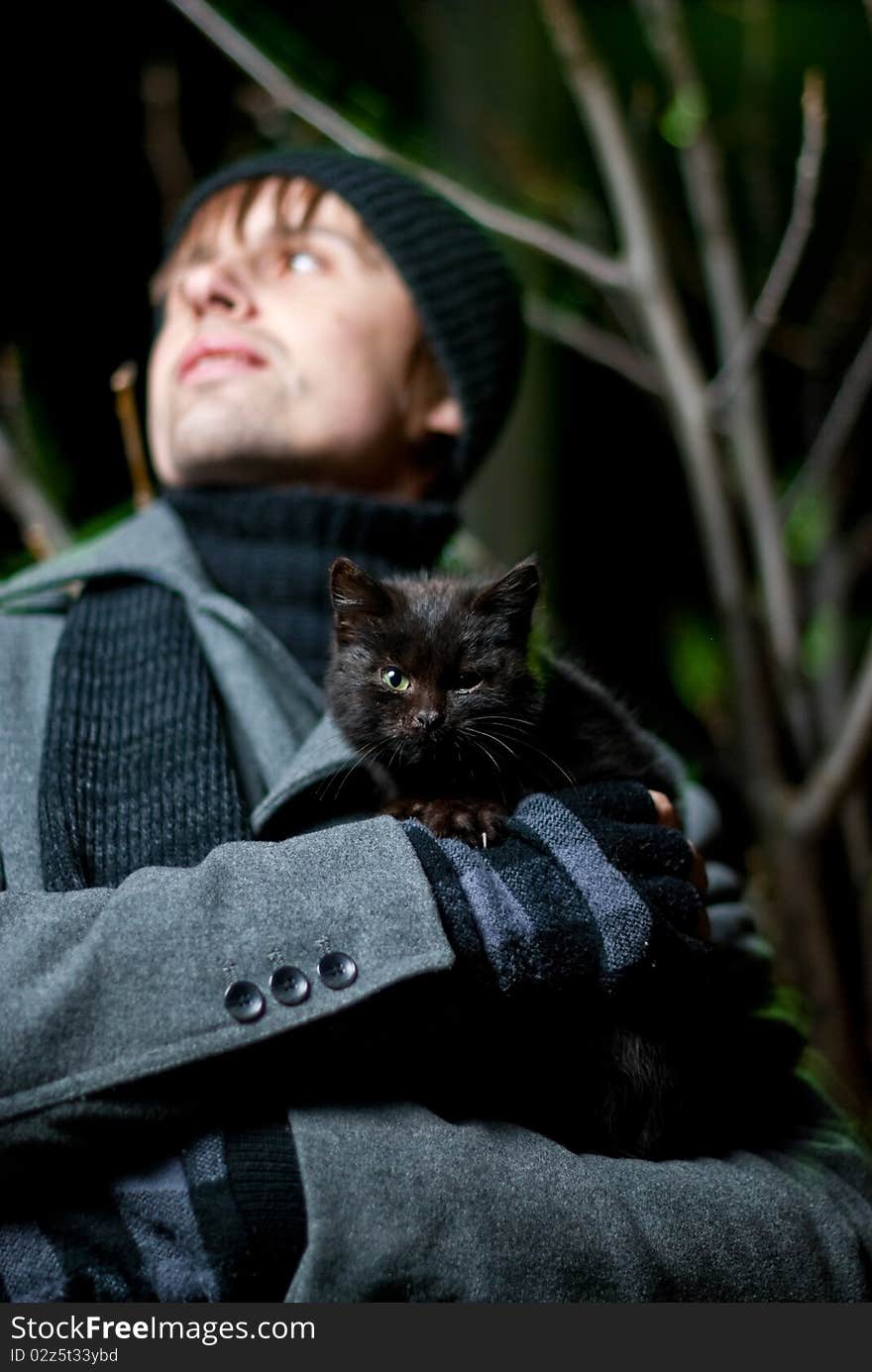 Young man holding black cat in his arms outdoor. Young man holding black cat in his arms outdoor