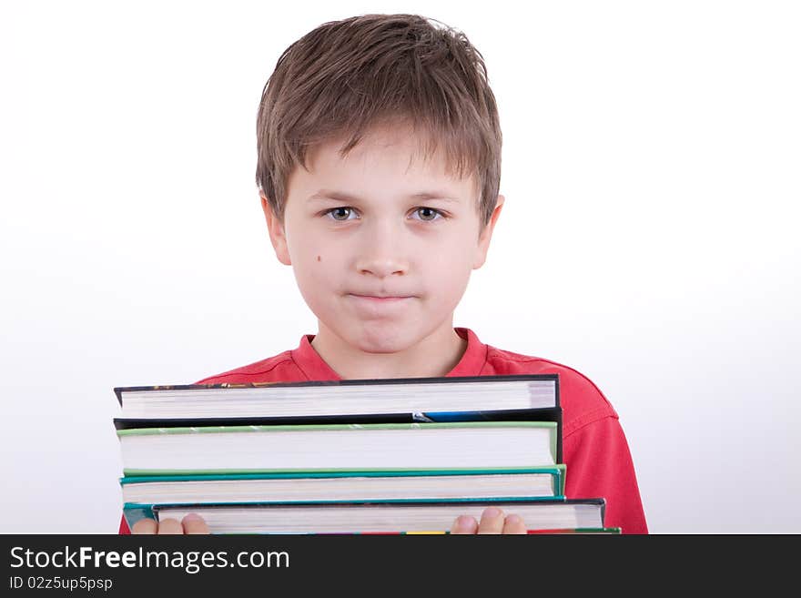 The boy holds a pile of books