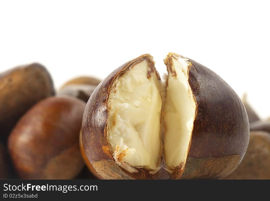 Heap of chestnuts with one cracked on over white background. Heap of chestnuts with one cracked on over white background