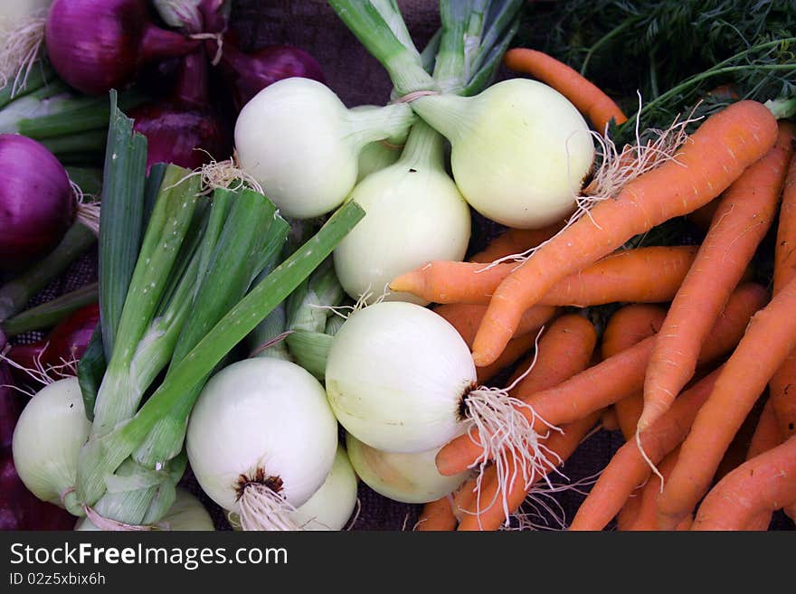 Colorful fresh vegetables carrots and onions at farmer’s market