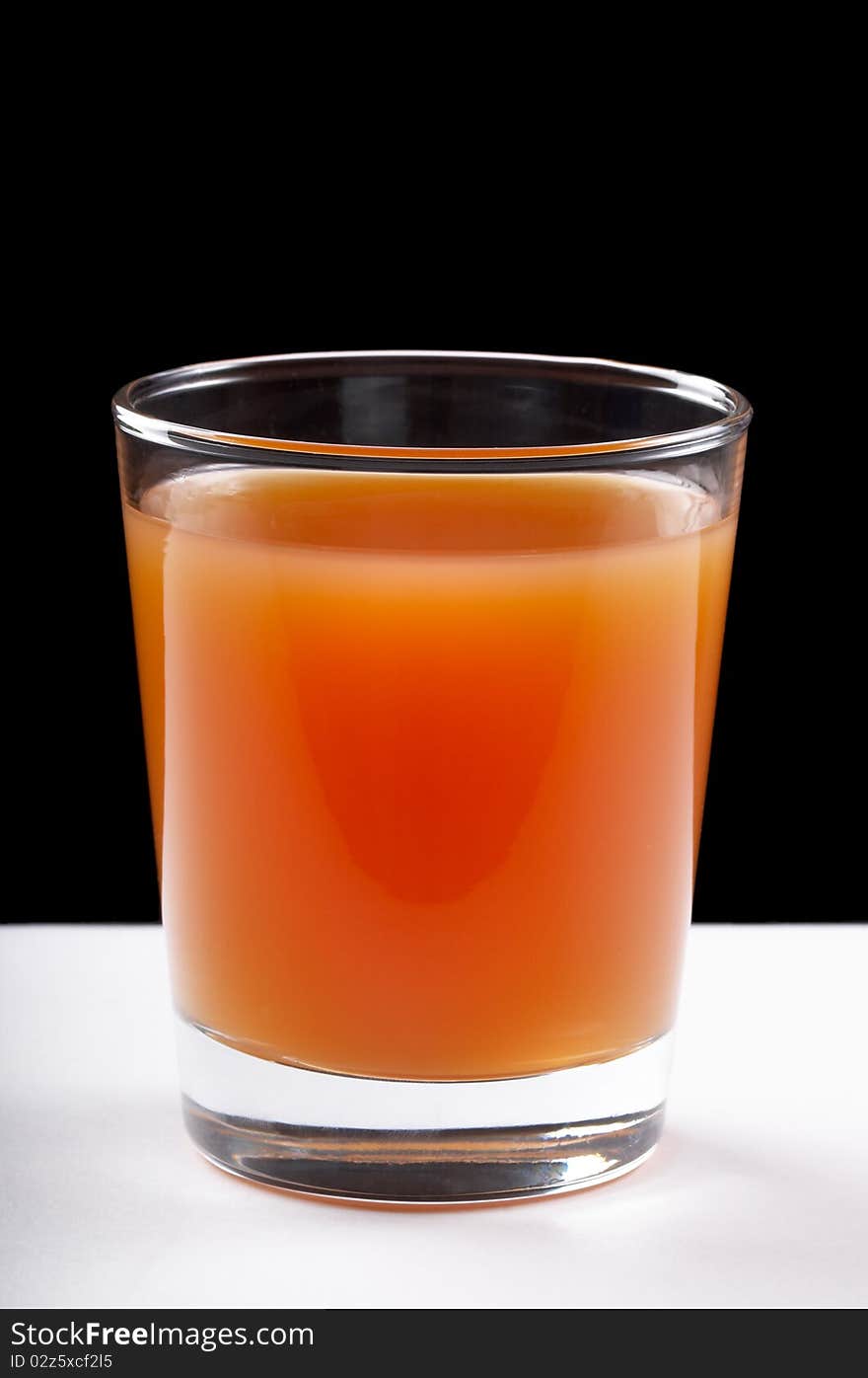 Grapefruit juce in the glass over black and white background. Grapefruit juce in the glass over black and white background