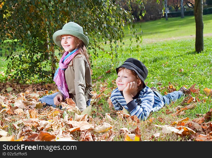 Happy girl and boy  enjoying golden autumn