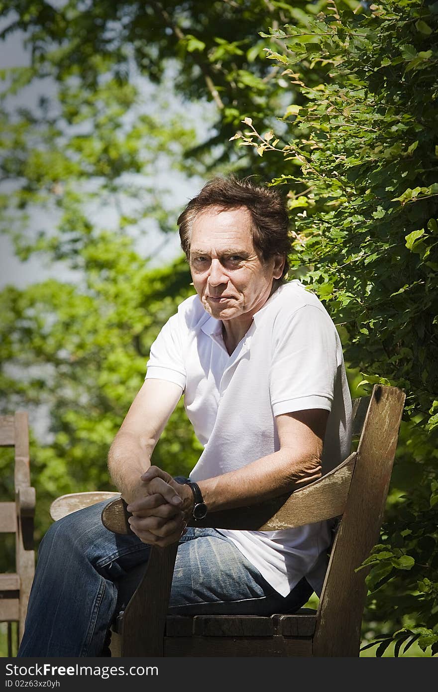 Portrait of an elderly man sitting in the park. Portrait of an elderly man sitting in the park