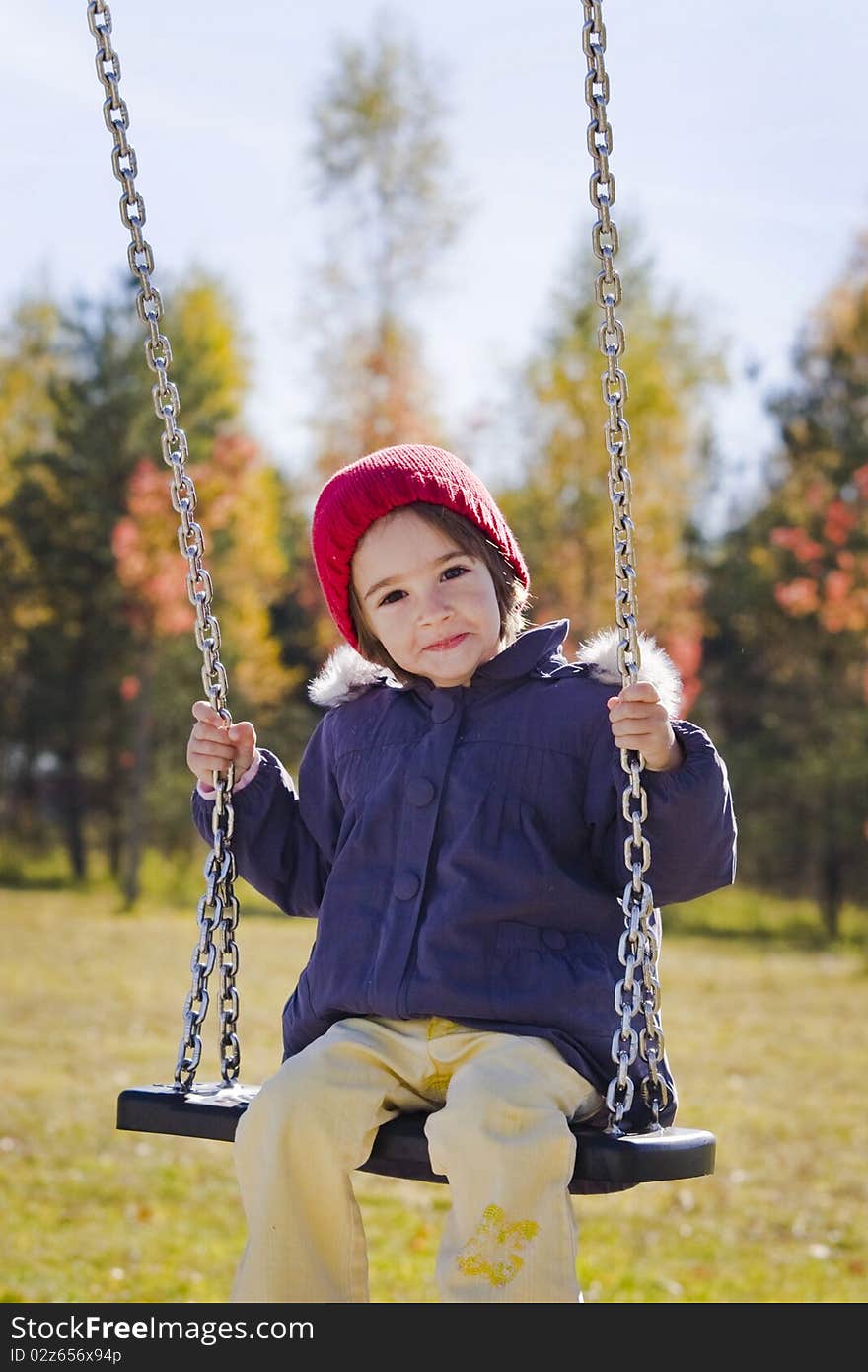 Happy little girl swinging on autumn day. Happy little girl swinging on autumn day