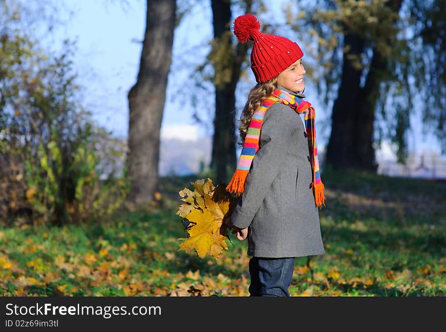 Little Miss. Pretty cute girl walks in autumn park